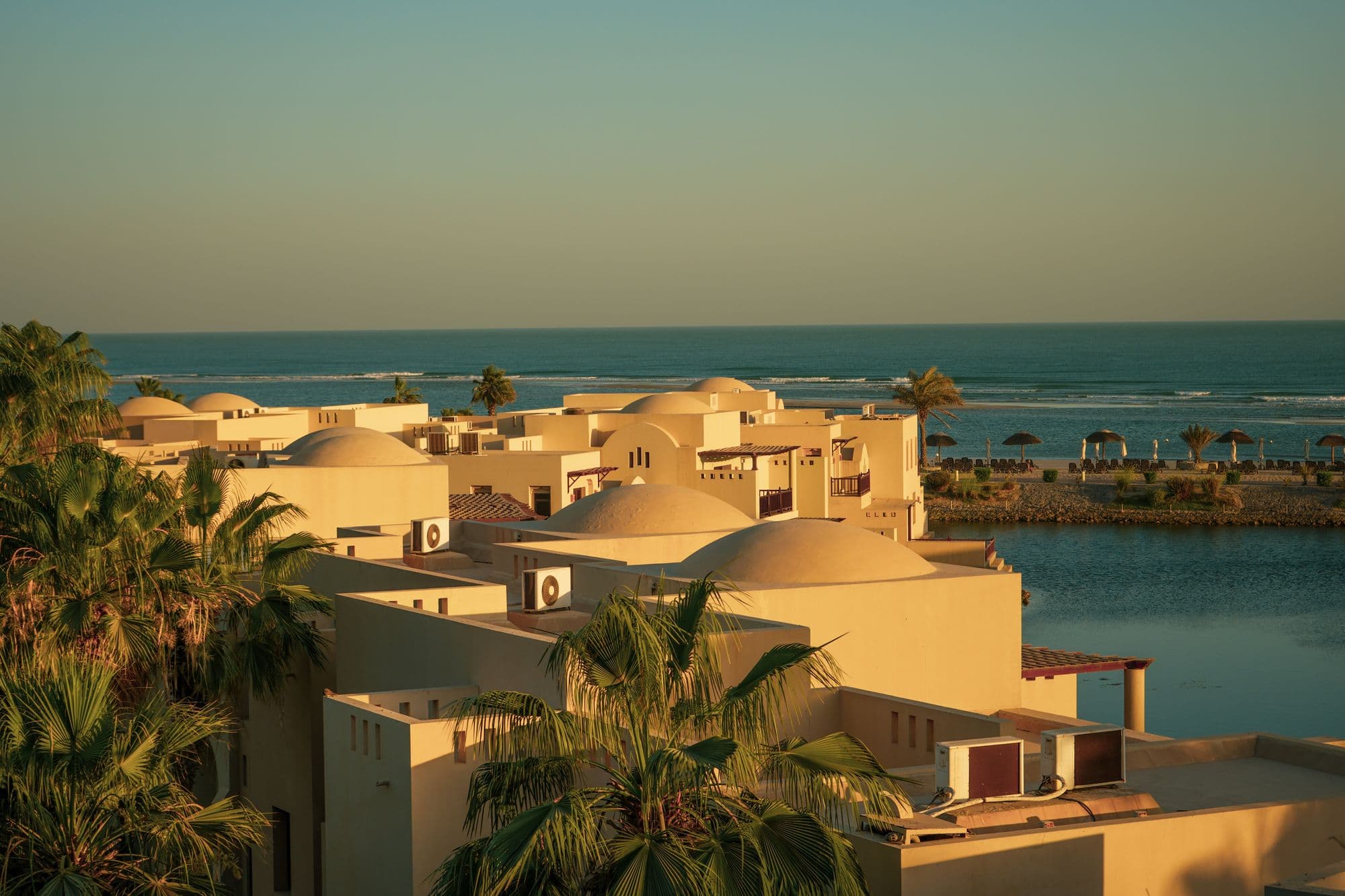 Aerial view of coastal villas at golden hour.