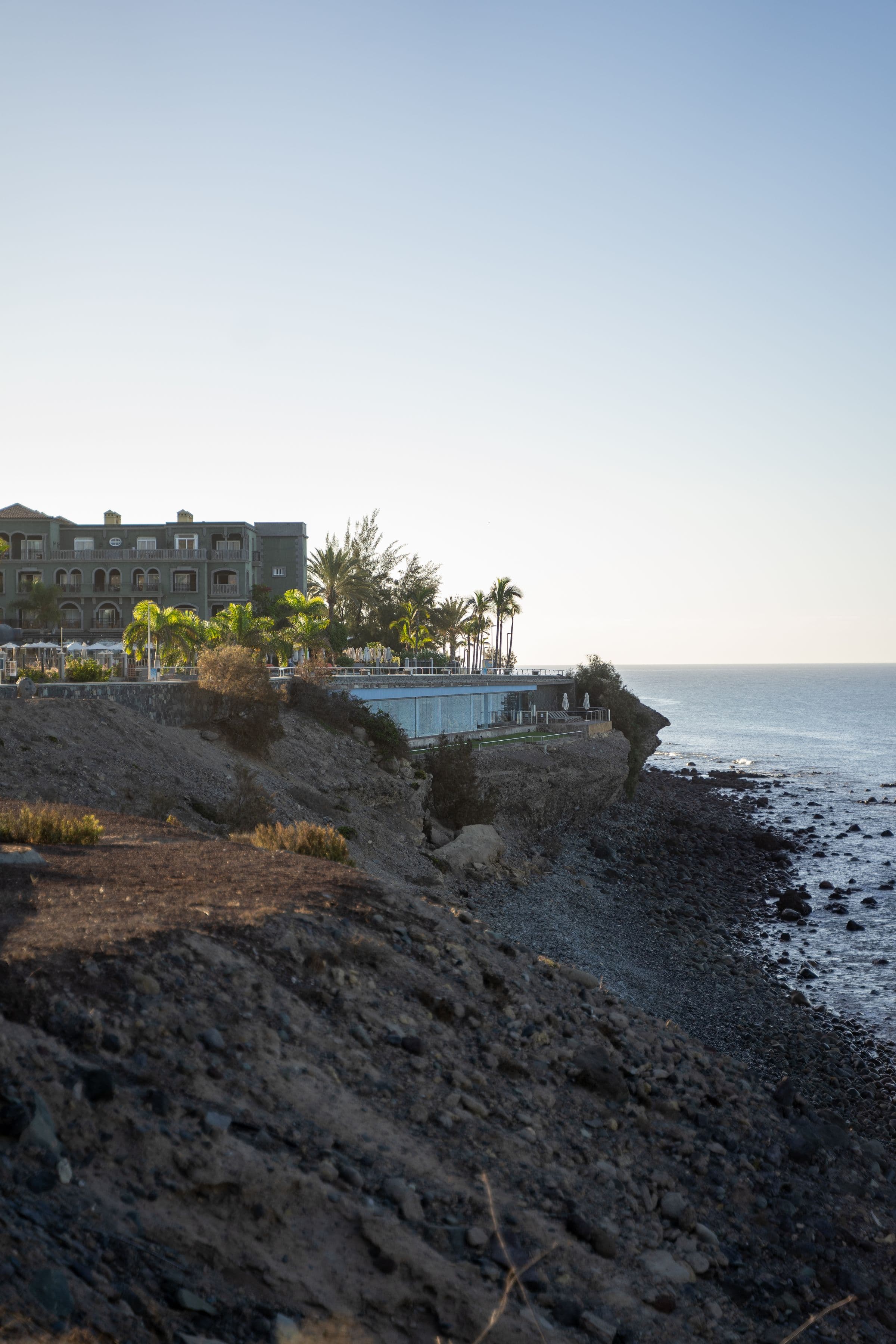 Luxury coastal resort architecture above the water at dusk.